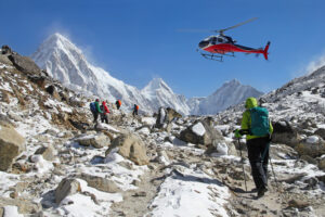 A trekker looks up to a helicopter flying low in the vicinity of Everest Base Camp