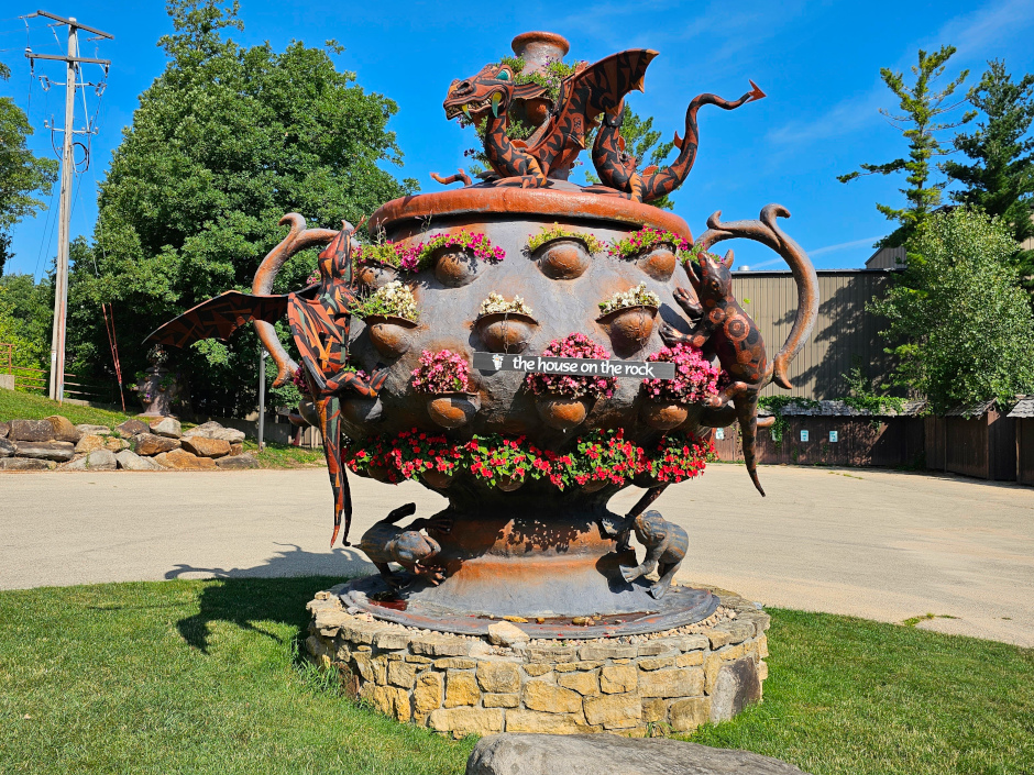 Photograph of a large, ornate jug surrounded by dragon statues