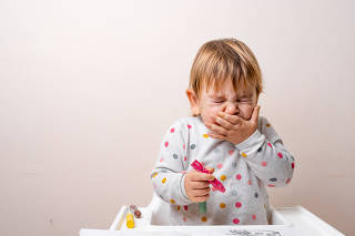 Toddler child sneezing while drying with crayons. Baby with allergy or cold from daycare or kindergarten. Germs paediatric medicine