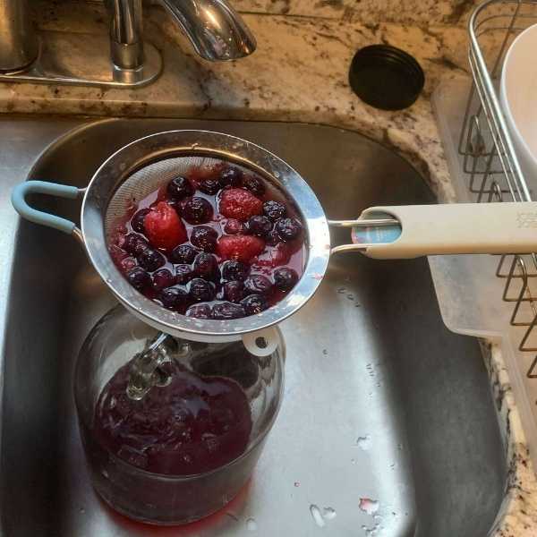 Image of Step 3: Strain Saucy Liquid While Adding To Fermentation ContainerOnce...