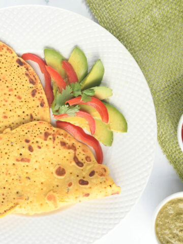 Chickpeas pancakes served with tomato sauce and green chutney.