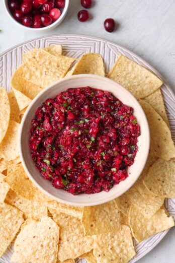 Cranberry salsa on a platter with tortilla chips.