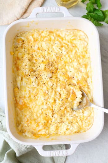 Baked scrambled feta eggs in a baking dish with a spoon dipped in.