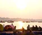 Devotees take a holy dip at the Sangam during sunset