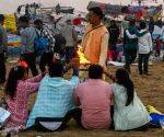 A priest offers aarti to devotees at the Sangam