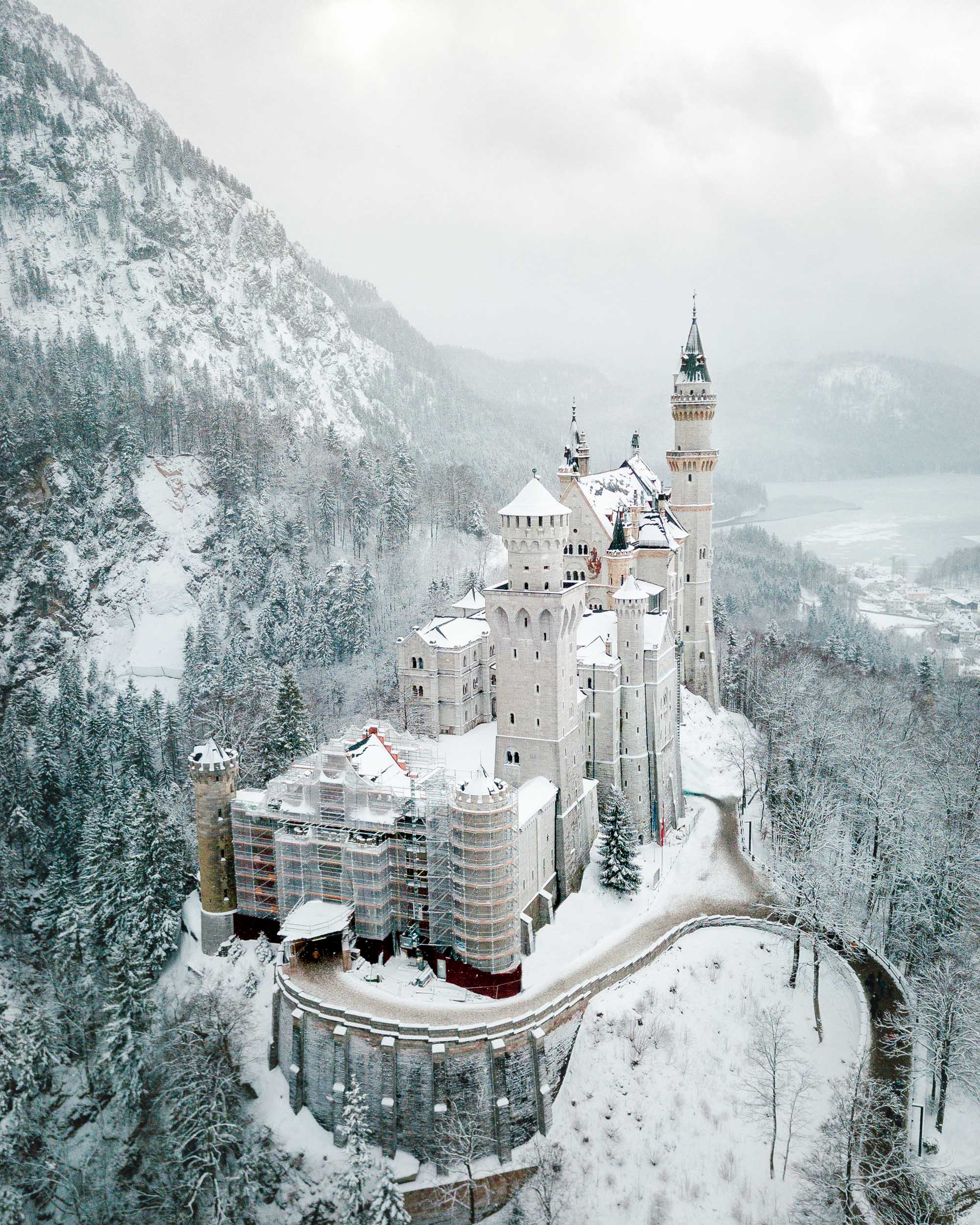 Neuschwanstein Castle in the snow in winter birds eye view Marienbrucke lookout best spot to photograph german fairytale castle