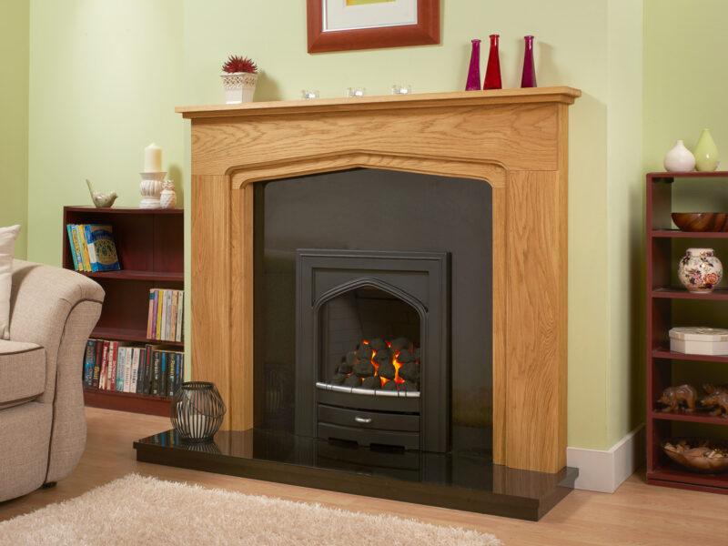 Oak fireplace with arch finished in light oak accompanied with a polished granite hearth and back panel and black gas fire.