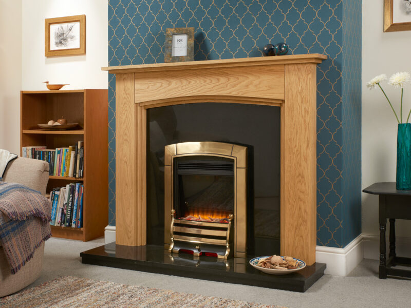 Oak fire surround with steps with a polished black granite hearth and back panel set and gold electric fire.