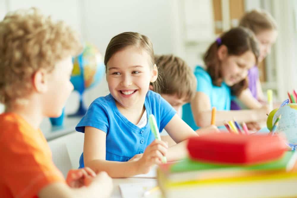 Smiling girl with classmates at school