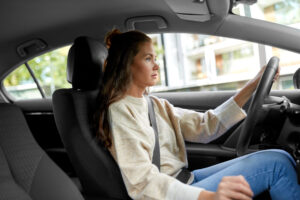 Young woman who meets the minimum age to rent a car driving a vehicle