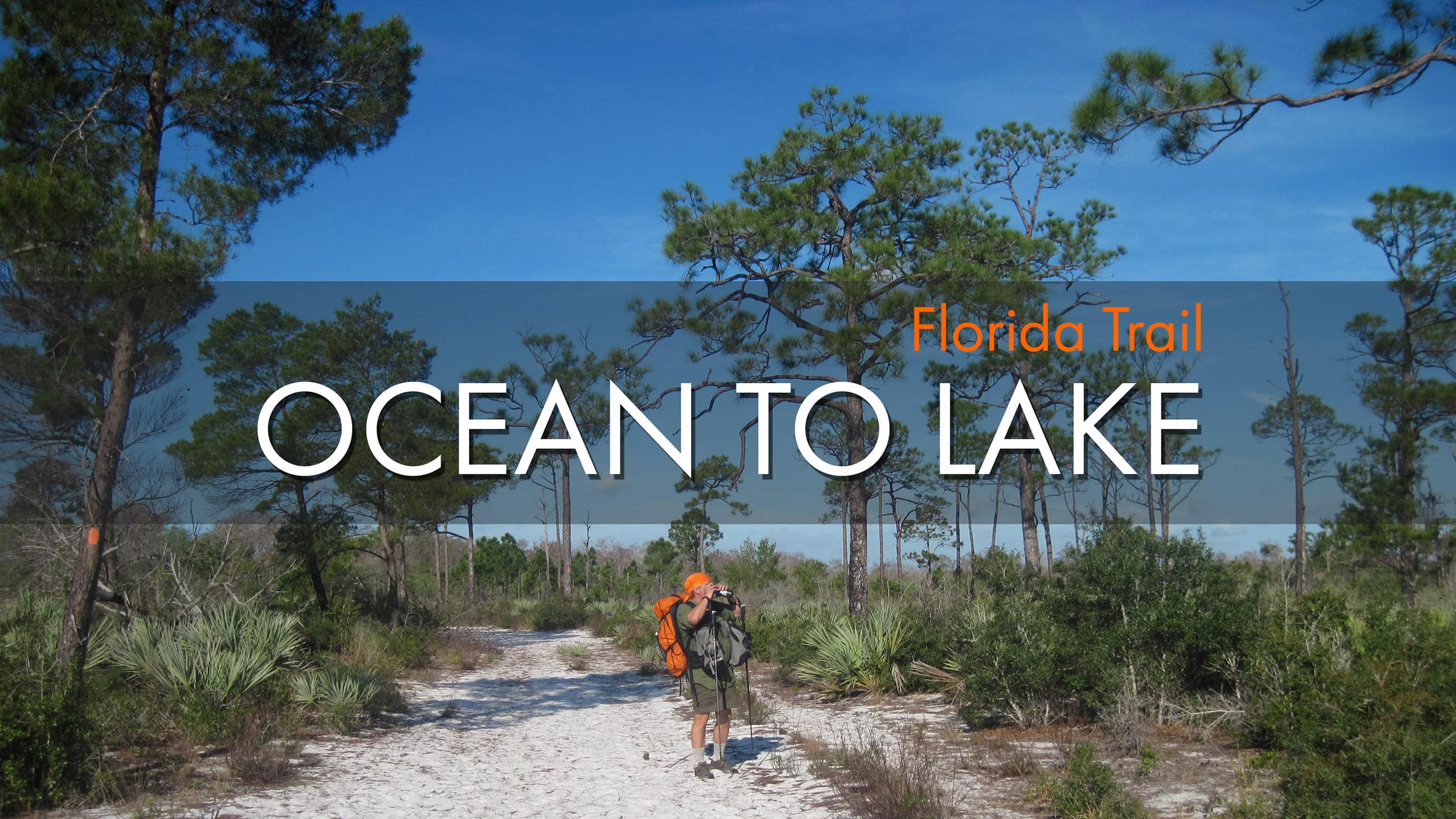 Words Florida Trail Ocean to Lake overlaid on a man with backpack pausing to watch a bird through binoculars in scrub habitat.