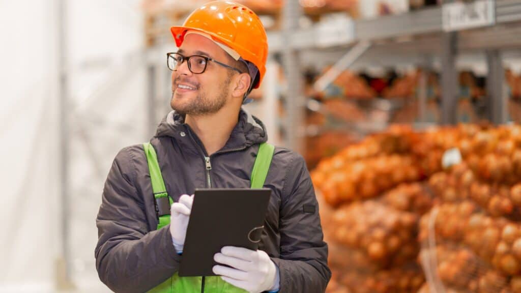 man at work wearing an orange har hat and carrying a clipboard