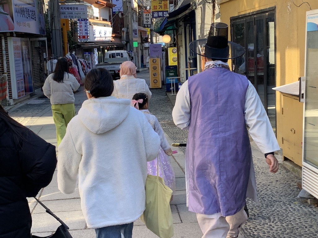 a group of people walking down a sidewalk