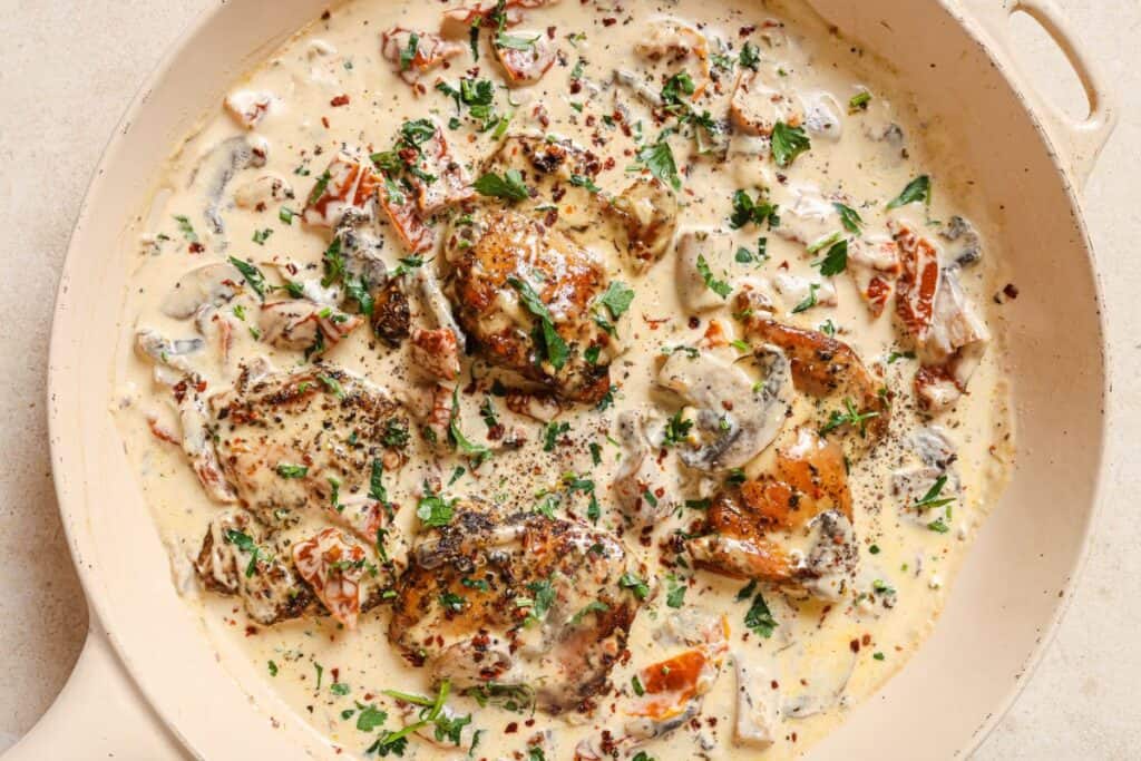 Chicken with creamy mushroom sauce in a pan.