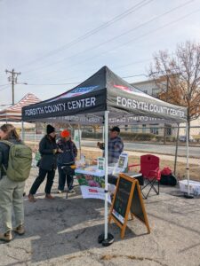 People at farmers market booth talking