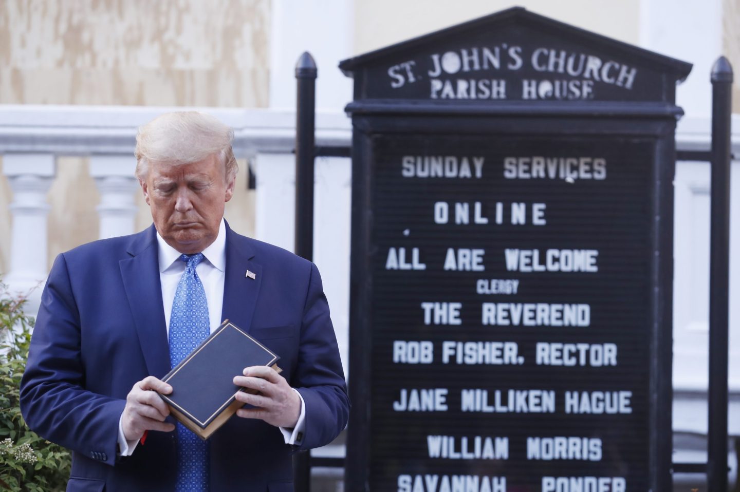 Donald Trump stands in front of a church holding a bible