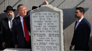 Republican presidential nominee Donald Trump, places a rock on the gravestone of Rabbi Menachem Mendel Schneerson as Ben Shapiro watches at Ohel Chabad Lubavitch on October 7, 2024 in New York City. (Michael M. Santiago/Getty Images)