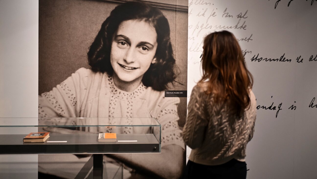 A person looks at a picture of Anne Frank at  "Anne Frank The Exhibition" at the Center for Jewish History.