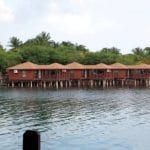 A cluster of wooden huts near a waterfront.