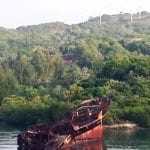 A rusty Galveston Cruise ship sits in the middle of a body of water.