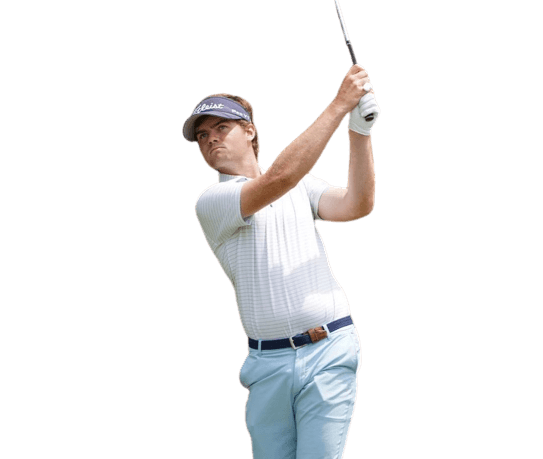 Zach Johnson in a dark gray shirt, white pants, and a white hat swinging holding his pose on his tee shot with a driver in hand