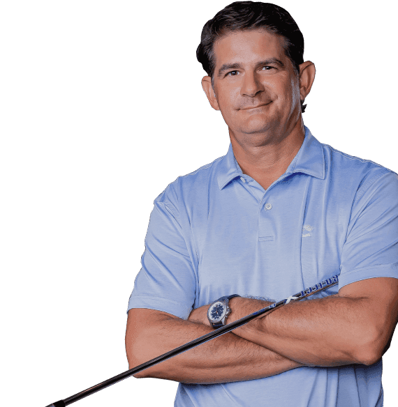 Jason Baile 2022 South Florida PGA Teacher of the Year in a light blue polo shirt and wavy hair, arms crossed with a golf club under his left arm, smirking in a friendly manner