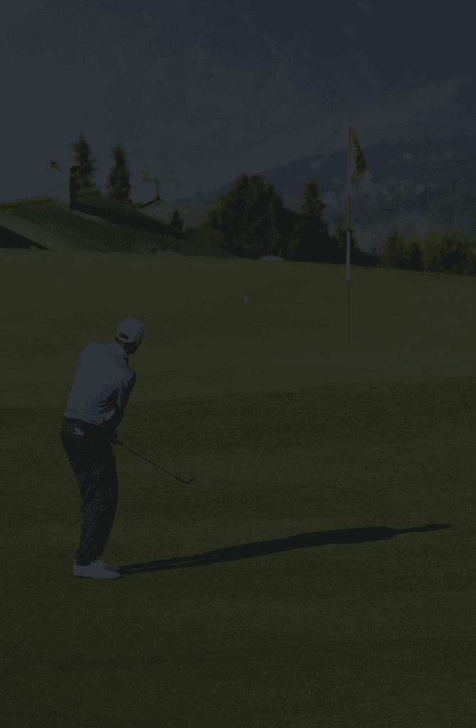 Generic faded background image of a golfer chipping to a red flag and mountains in the background