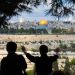 A Christian tourist on the Mount of Olives prays for the peace of Jerusalem.