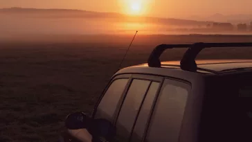 black suv on black sand during sunset