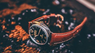 round silver-colored analog watch with brown leather strap