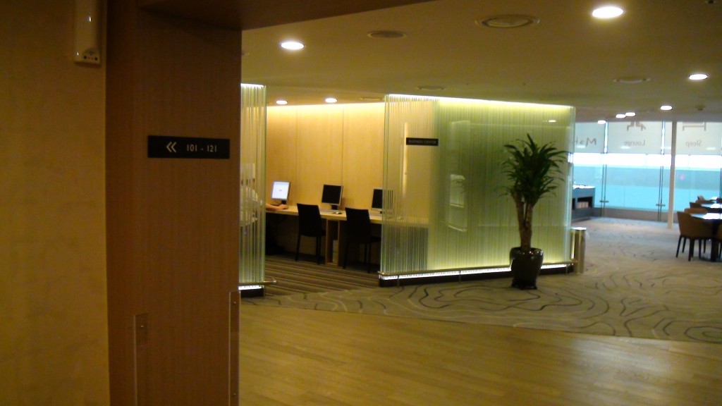 a room with a computer desk and a plant