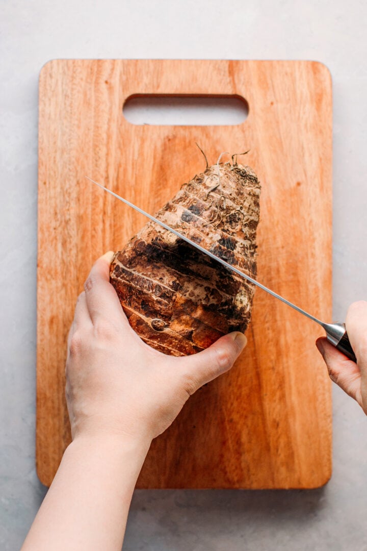 Slicing a large taro root.