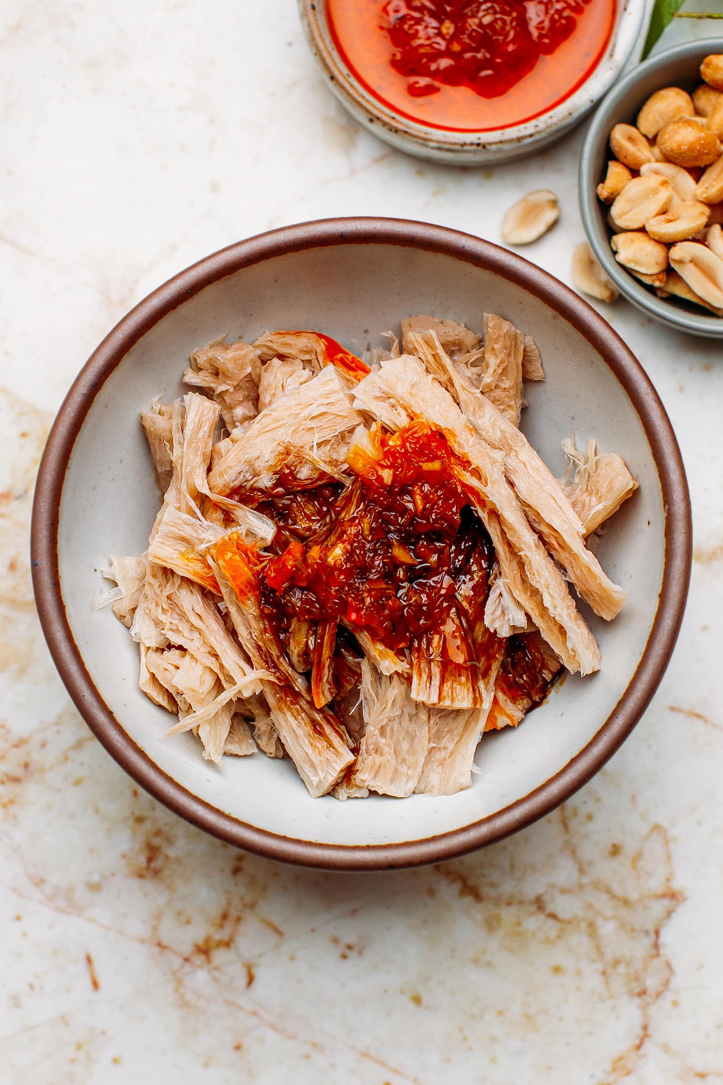 Shredded textured vegetable protein and saté in a bowl.