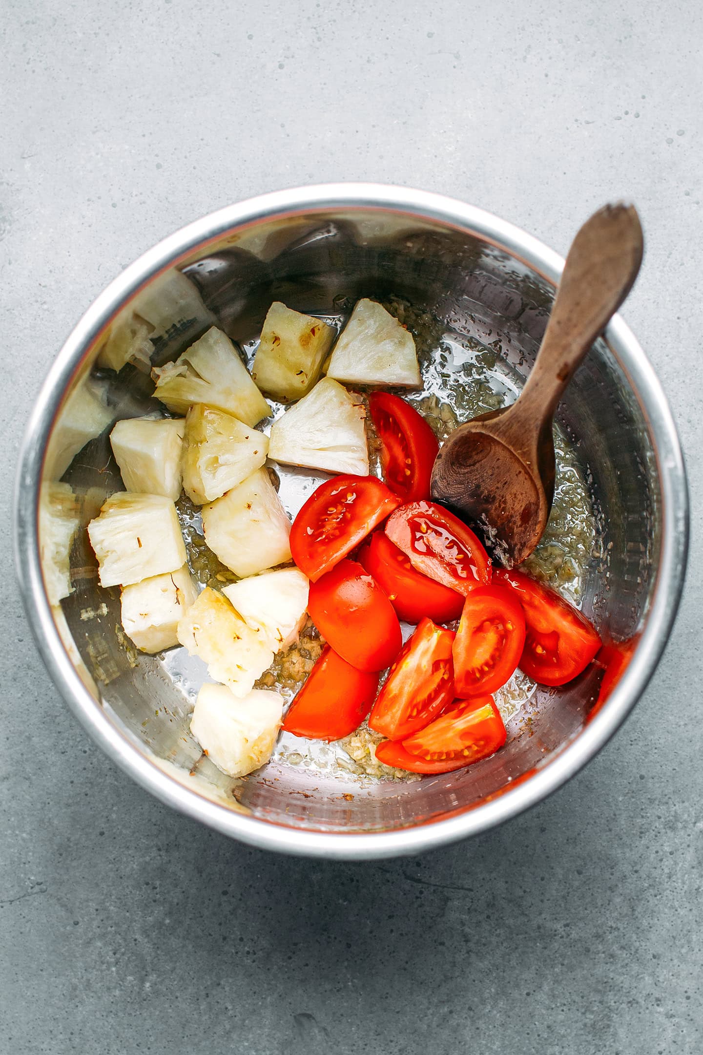 Pineapple and tomatoes in a pot.