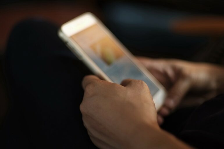 Blurred image of a woman'hand reading and sending information on mobile phones.