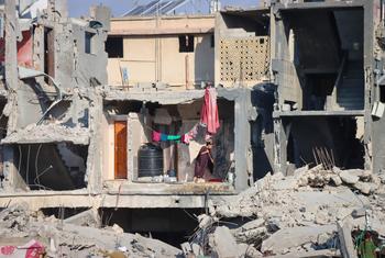 A woman cleans the floor of a destroyed building in Gaza.