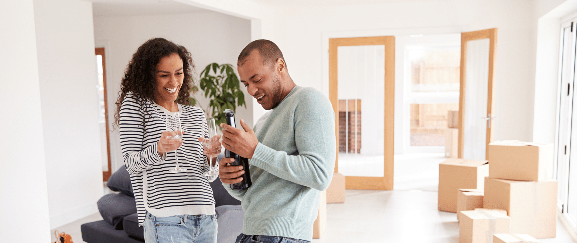 man and woman in new  home celebrating with champagne