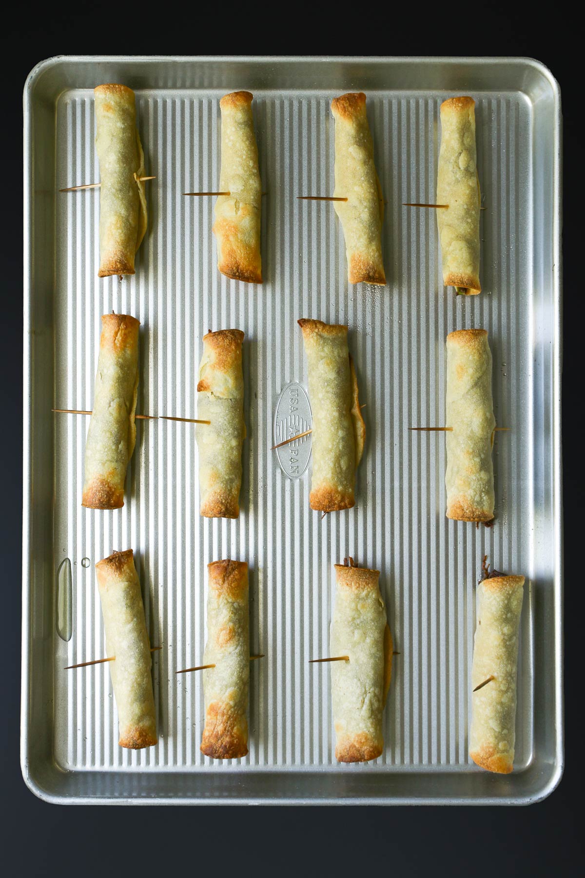 baked taquitos on baking sheet.