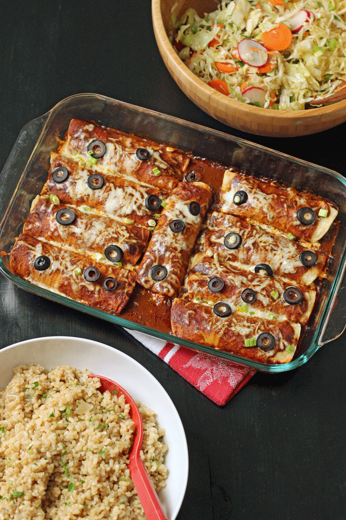 pan of enchiladas with salad and rice