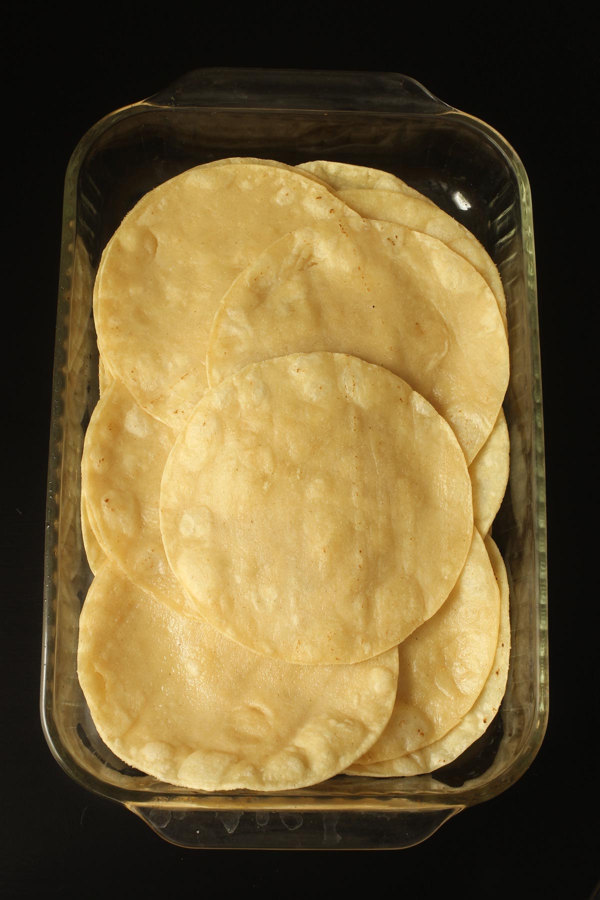 fried tortillas in glass baking dish.