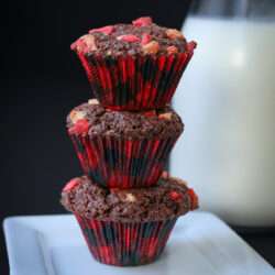 stack of three peppermint brownie bites on a white plate in front of a milk bottle.