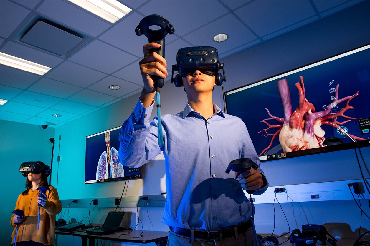 Students from the Carle Illinois College of Medicine use VR with screens showing the anatomy of human lungs and heart. 