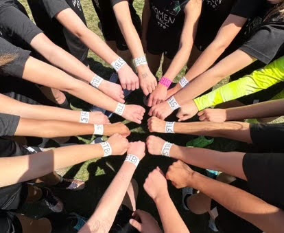  Grant Women's Soccer huddled with matching “Save the Bread” bracelets.
