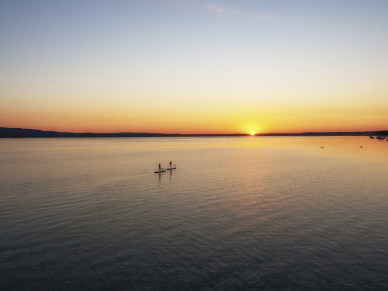 Paddle boarders cross Platte Lake, Michigan, where a decades-long campaign reduced algal blooms caused by runoff from a fish hatchery. Image: J. Carl Ganter/ Circle of Blue