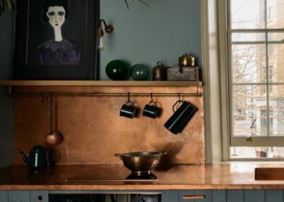 patina copper splashback in green kitchen