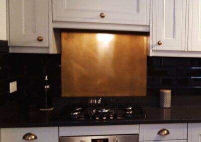 aged copper splashback in white kitchen