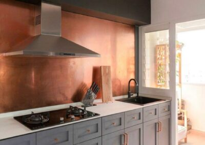 orange copper splashback in modern grey kitchen