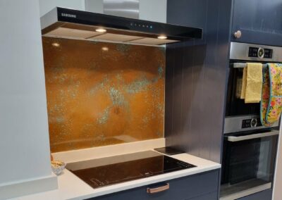 antiqued copper splashback in navy kitchen