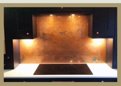 Aged copper splashback with gloss finish in modern kitchen