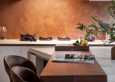 copper splashback behind wooden kitchen island